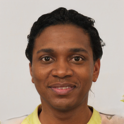 Joyful black young-adult male with short  black hair and brown eyes