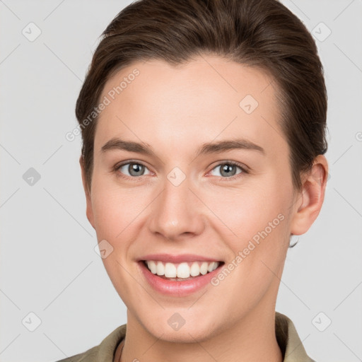 Joyful white young-adult female with short  brown hair and grey eyes