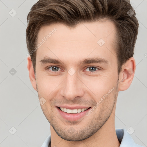 Joyful white young-adult male with short  brown hair and grey eyes