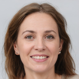 Joyful white adult female with long  brown hair and grey eyes