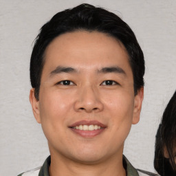 Joyful asian young-adult male with short  black hair and brown eyes