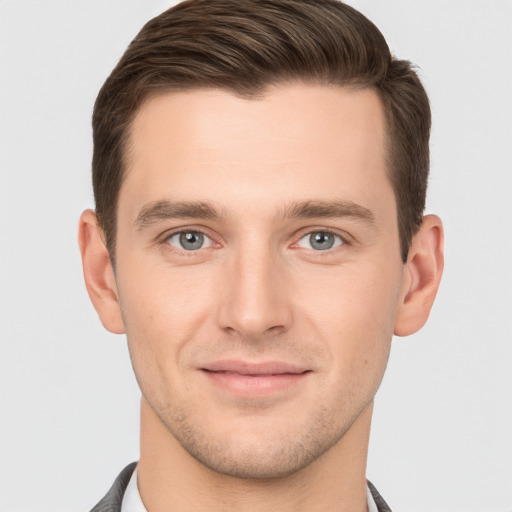 Joyful white young-adult male with short  brown hair and grey eyes