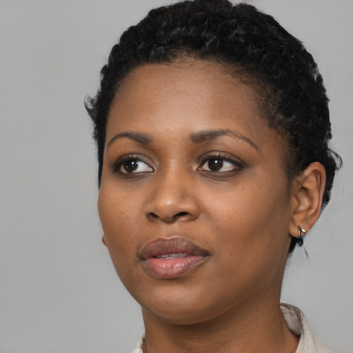 Joyful black young-adult female with short  black hair and brown eyes