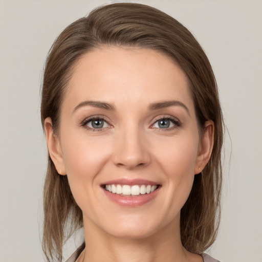 Joyful white young-adult female with medium  brown hair and grey eyes