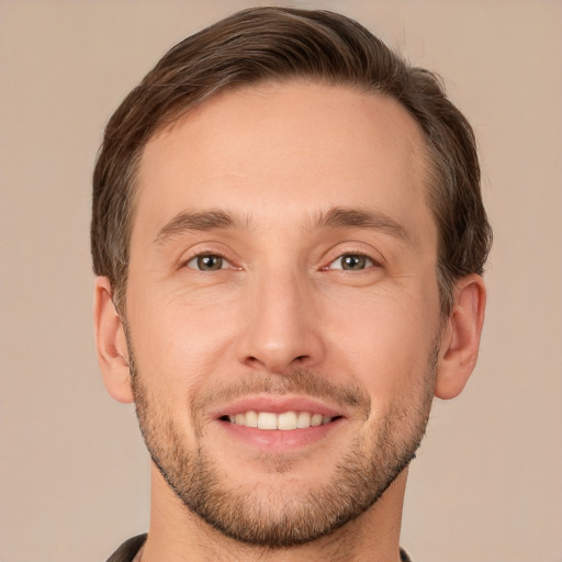 Joyful white young-adult male with short  brown hair and grey eyes