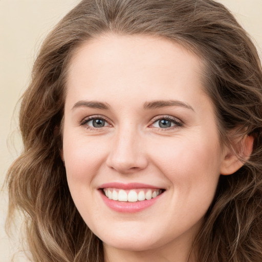 Joyful white young-adult female with long  brown hair and green eyes