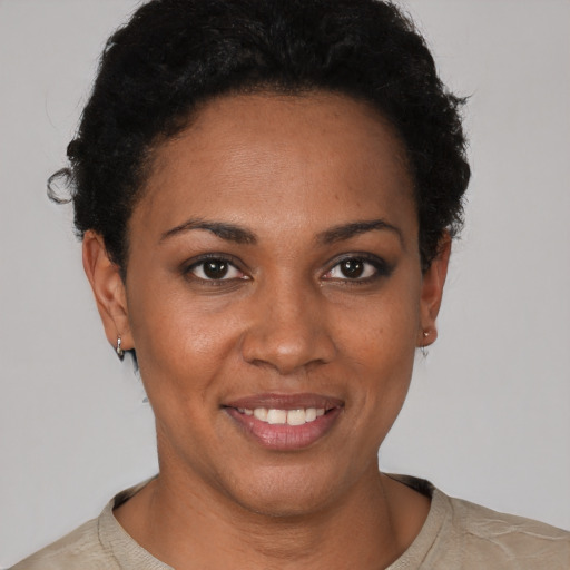 Joyful black young-adult female with short  brown hair and brown eyes