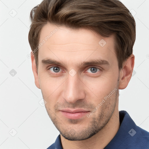 Joyful white young-adult male with short  brown hair and grey eyes