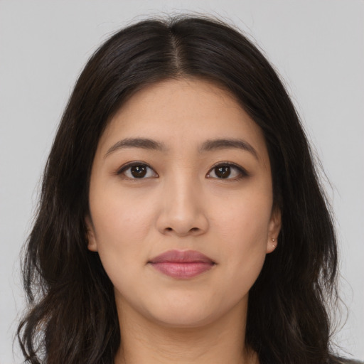 Joyful latino young-adult female with long  brown hair and brown eyes