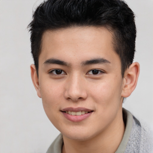 Joyful asian young-adult male with short  brown hair and brown eyes