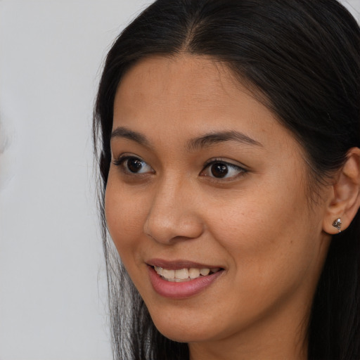 Joyful asian young-adult female with long  brown hair and brown eyes