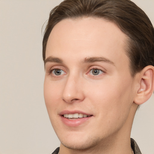 Joyful white young-adult male with short  brown hair and grey eyes