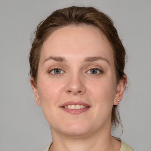 Joyful white adult female with medium  brown hair and blue eyes