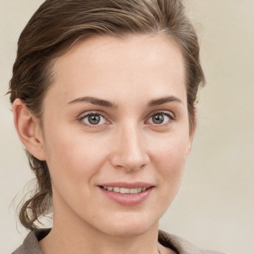 Joyful white young-adult female with medium  brown hair and grey eyes