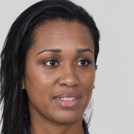 Joyful black young-adult female with long  brown hair and brown eyes