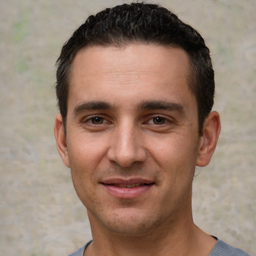 Joyful white young-adult male with short  black hair and brown eyes