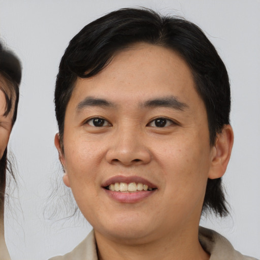 Joyful asian young-adult male with medium  brown hair and brown eyes