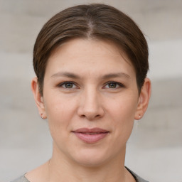 Joyful white young-adult female with short  brown hair and grey eyes