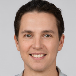 Joyful white young-adult male with short  brown hair and grey eyes