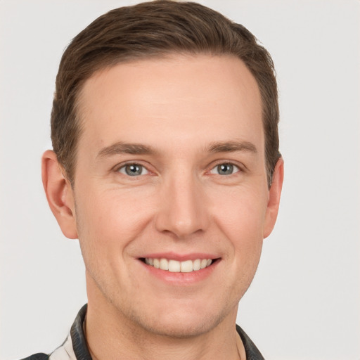 Joyful white young-adult male with short  brown hair and grey eyes