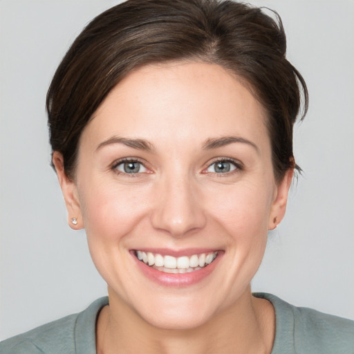 Joyful white young-adult female with short  brown hair and grey eyes