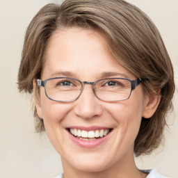 Joyful white adult female with medium  brown hair and blue eyes