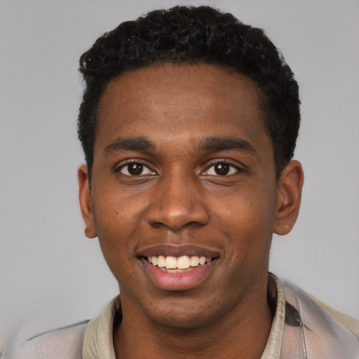 Joyful black young-adult male with short  black hair and brown eyes