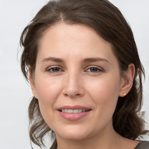 Joyful white young-adult female with medium  brown hair and grey eyes