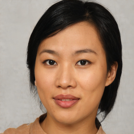 Joyful asian young-adult female with medium  black hair and brown eyes