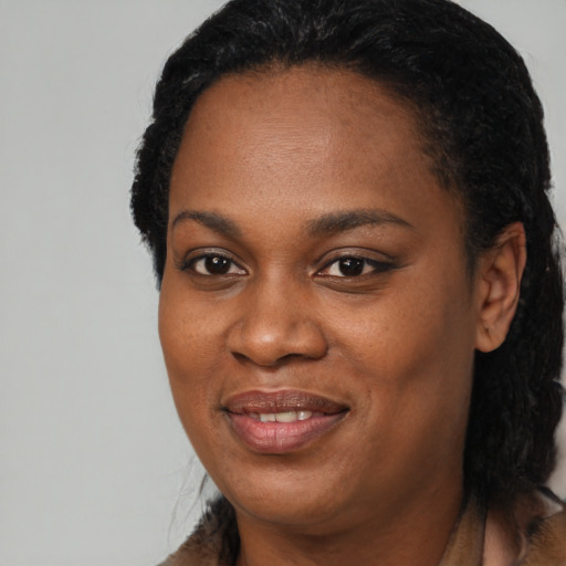 Joyful black young-adult female with long  black hair and brown eyes