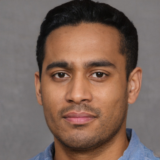 Joyful latino young-adult male with short  black hair and brown eyes