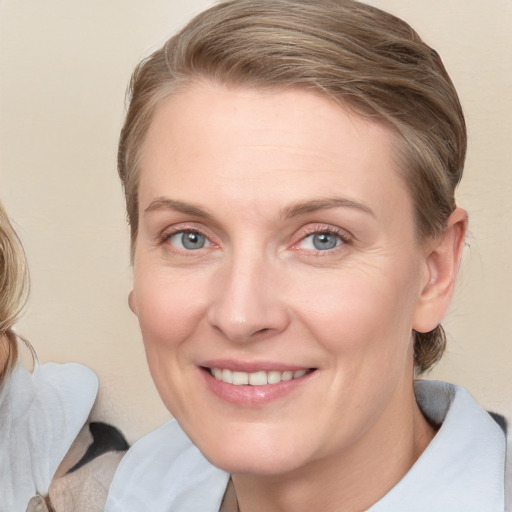 Joyful white adult female with medium  brown hair and blue eyes