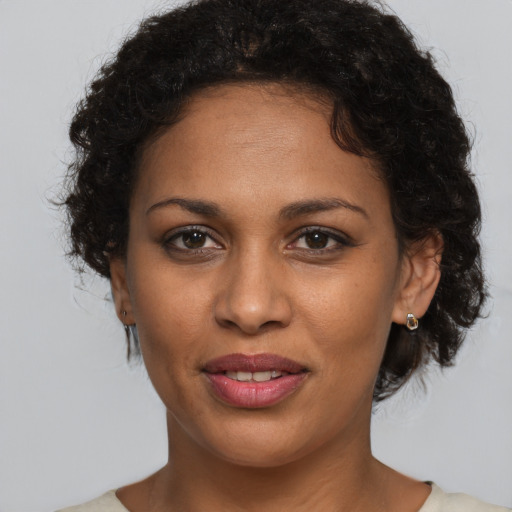 Joyful black young-adult female with short  brown hair and brown eyes