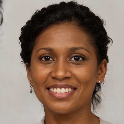 Joyful black young-adult female with medium  brown hair and brown eyes