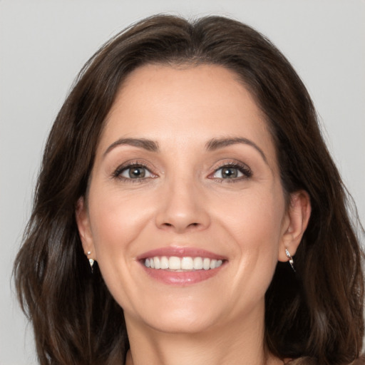 Joyful white adult female with medium  brown hair and brown eyes