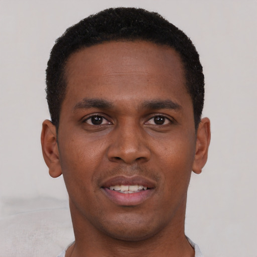 Joyful black young-adult male with short  black hair and brown eyes