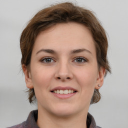 Joyful white young-adult female with medium  brown hair and grey eyes