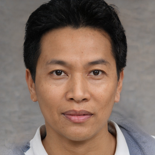 Joyful asian adult male with short  black hair and brown eyes