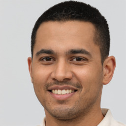 Joyful latino young-adult male with short  brown hair and brown eyes