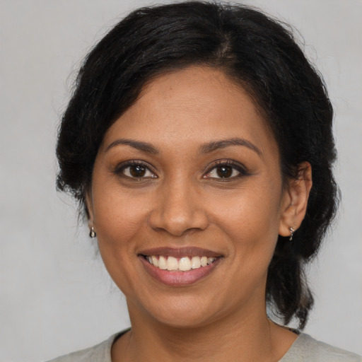 Joyful black young-adult female with medium  brown hair and brown eyes