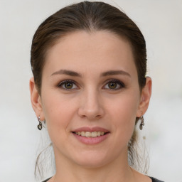 Joyful white young-adult female with medium  brown hair and grey eyes