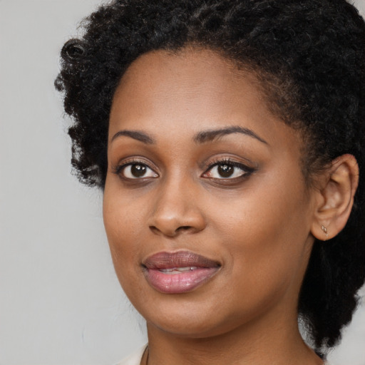 Joyful black young-adult female with long  brown hair and brown eyes