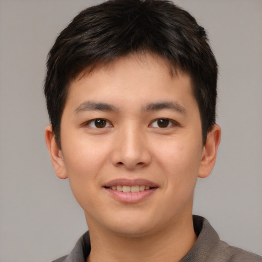 Joyful asian young-adult male with short  brown hair and brown eyes