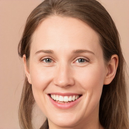 Joyful white young-adult female with long  brown hair and grey eyes