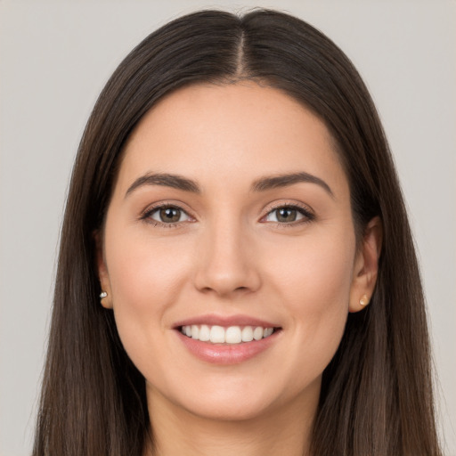 Joyful white young-adult female with long  brown hair and brown eyes