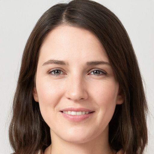 Joyful white young-adult female with long  brown hair and grey eyes