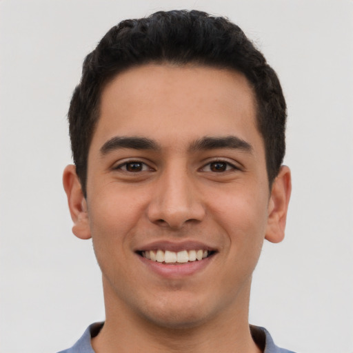 Joyful latino young-adult male with short  black hair and brown eyes