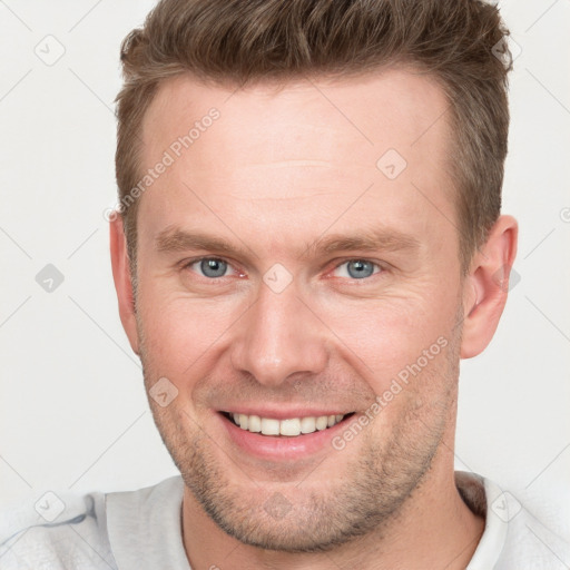 Joyful white young-adult male with short  brown hair and grey eyes