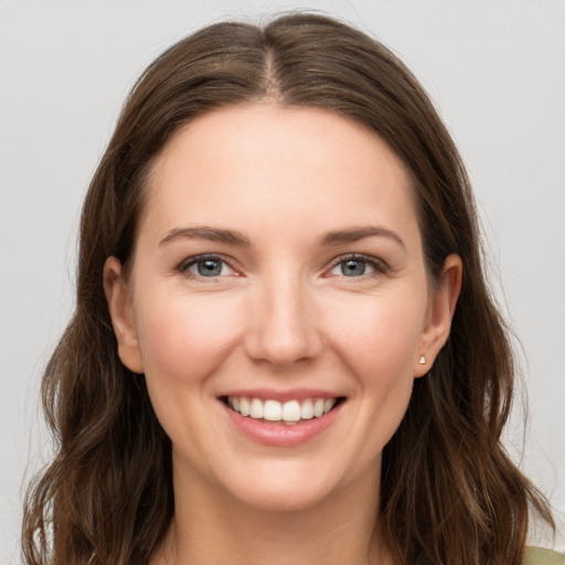 Joyful white young-adult female with long  brown hair and grey eyes