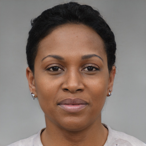 Joyful black young-adult female with short  black hair and brown eyes